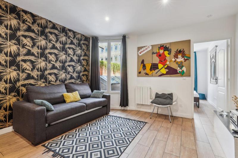 uma sala de estar com um sofá e uma cadeira em 201 Suite Anne - Superbe appartement em Puteaux