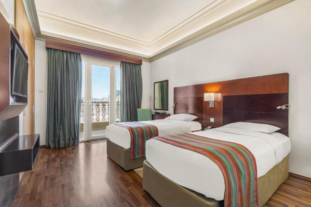 Postel nebo postele na pokoji v ubytování Al Khoory Hotel Apartments Al Barsha