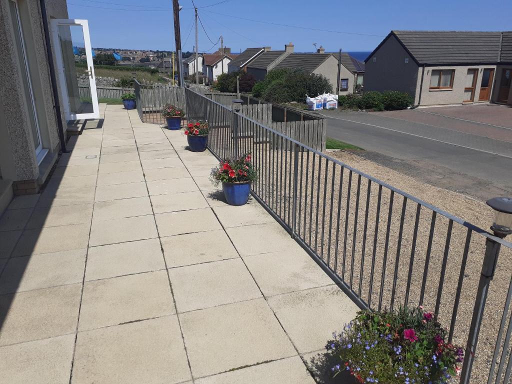 a sidewalk with potted plants and a fence at Beach view in Spittal