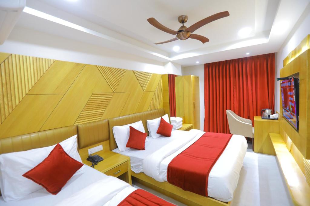 um quarto de hotel com duas camas e uma televisão em Hotel The Glitz em Nova Deli