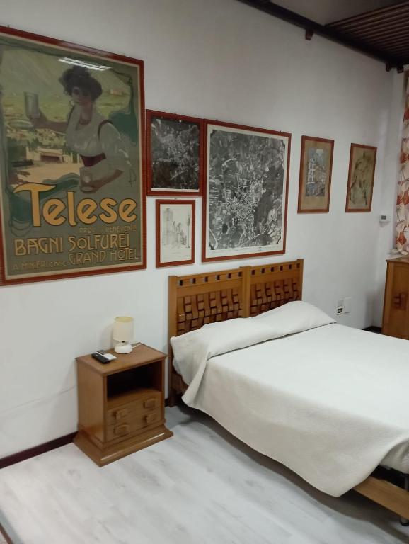 een slaapkamer met een bed en foto's aan de muur bij Studio Notte Guest Rooms in Telese