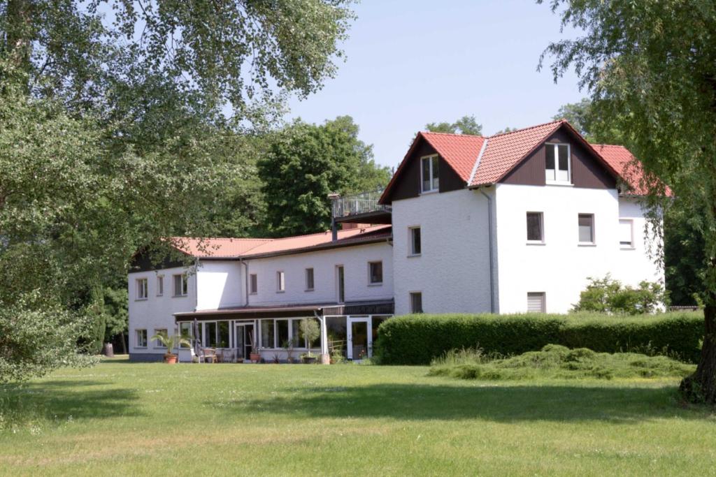 にあるLandhaus Wolziger Seeの赤屋根の大白屋敷