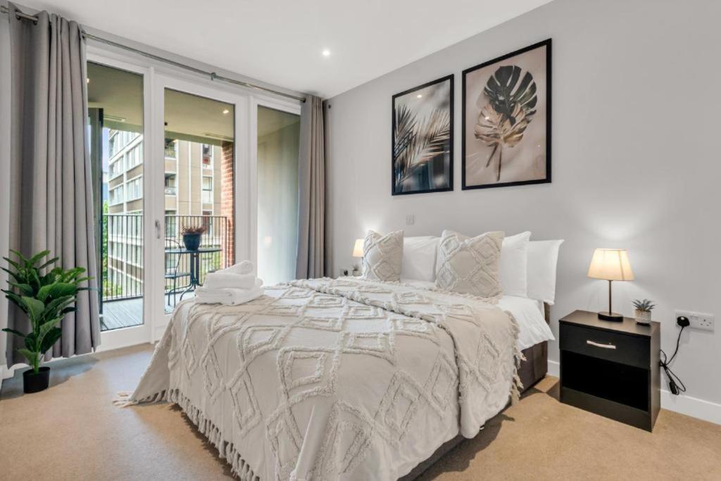 una camera bianca con un grande letto e una finestra di Large 2 Bed Apartment London Catford Lewisham - Perfect for Long Stays a Londra