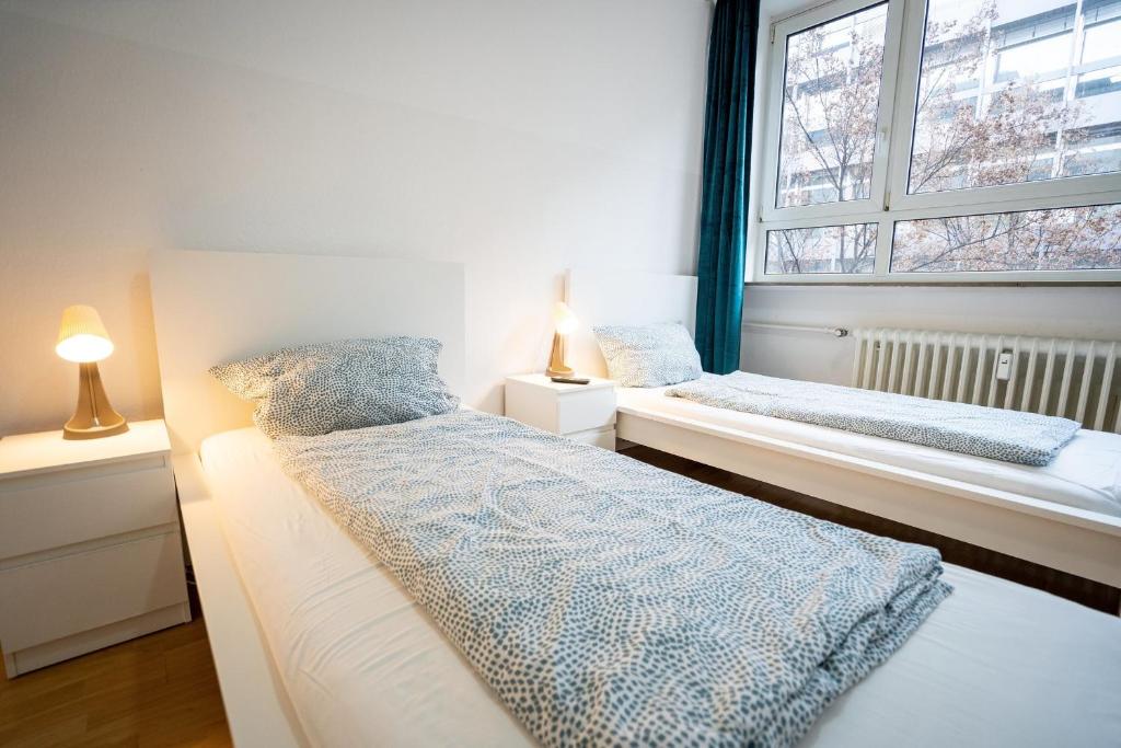1 dormitorio con 2 camas y ventana en ATRIUM - großzügige Wohnung LUDWIG79 en Ludwigshafen am Rhein