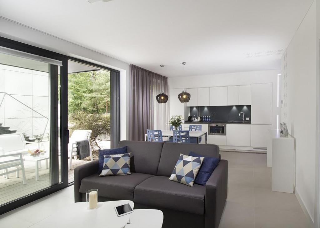 Una sala de estar con un sofá y una cocina. en Rosevia Resort & Spa, en Jastrzębia Góra