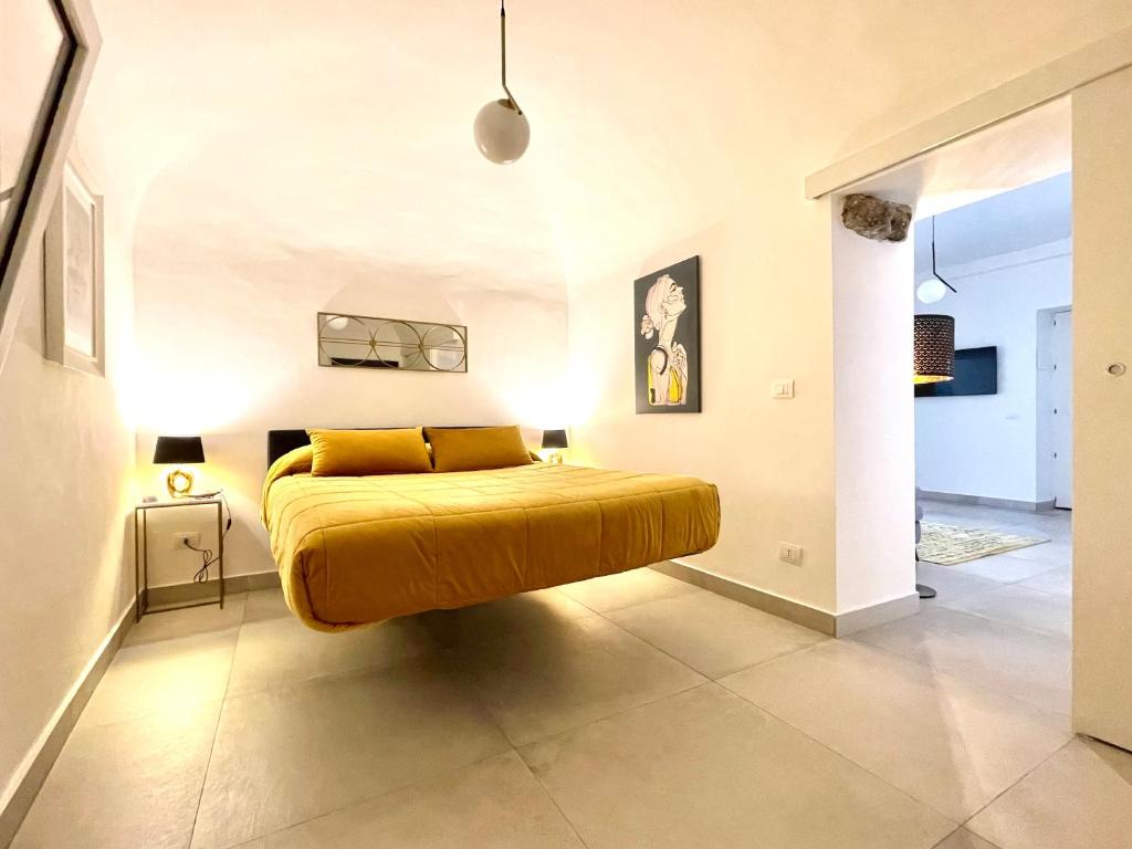 a bedroom with a yellow bed in a room at Sangiuliano Holiday Home in Catania