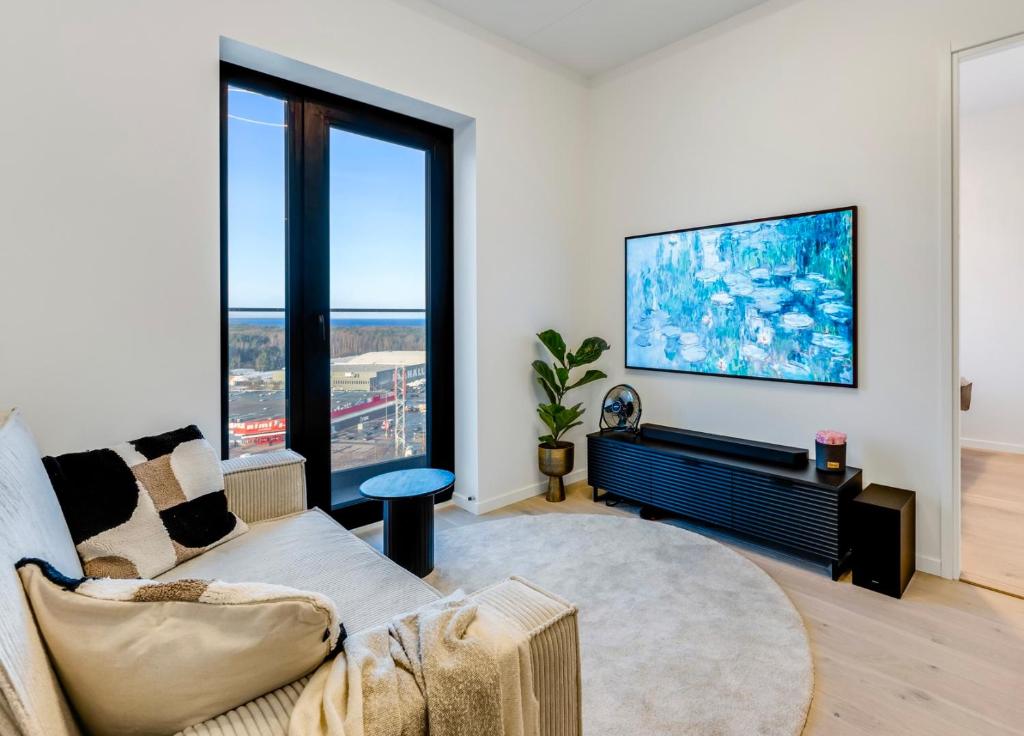 a living room with a couch and a large window at Sea view 16 floor premium apartment in Tallinn