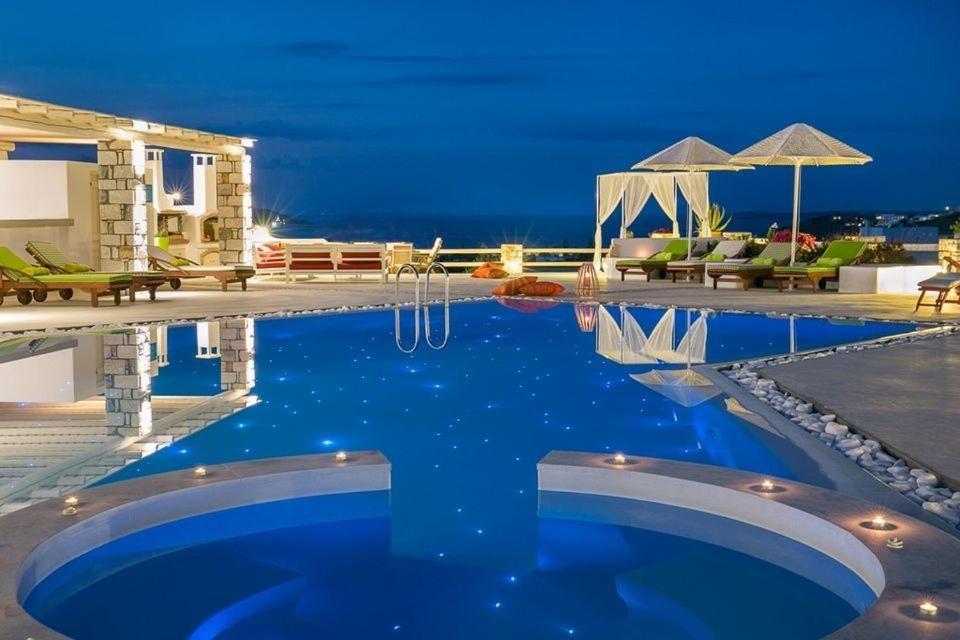 a large swimming pool with blue water in front of a building at Luxury Paros Villa 2 Bedrooms Villa Royalty Beautiful Sea Views & Private Terrace Naousa in Kampos Paros