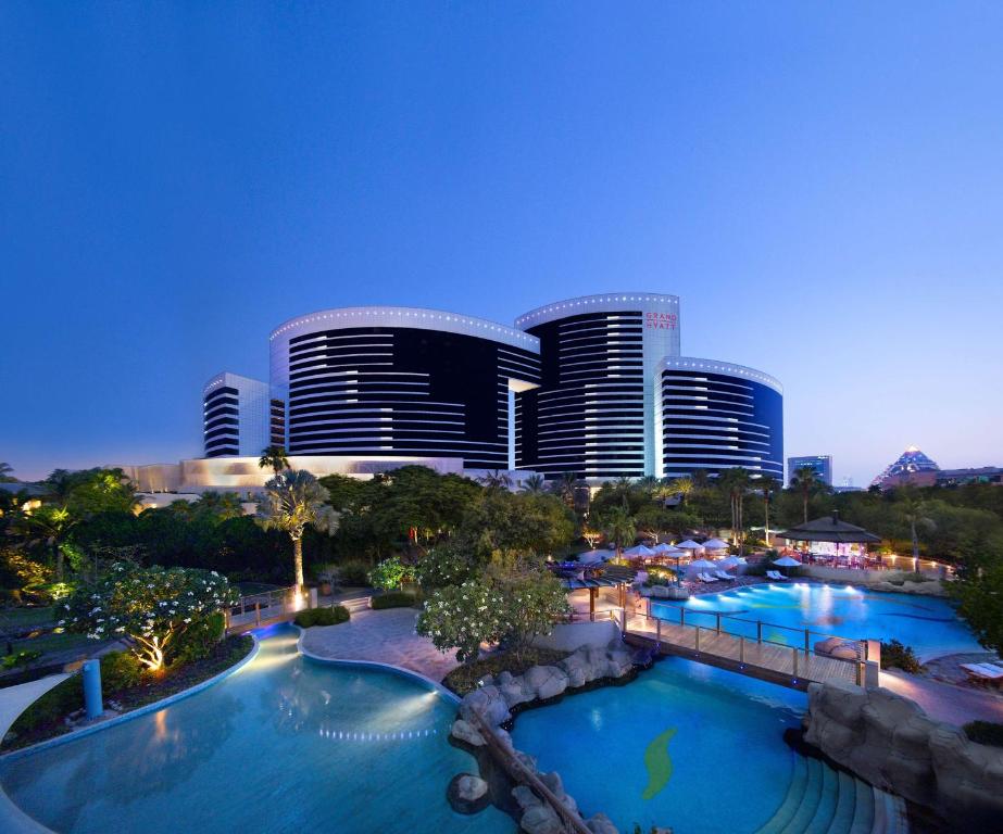 Blick auf ein Hotel mit zwei Pools und einer Stadt in der Unterkunft Grand Hyatt Dubai in Dubai