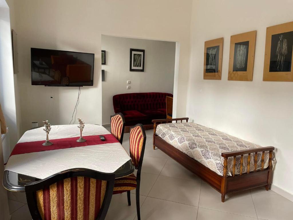 ピレウスにあるPiraeus art deco apartmentのベッド、テーブル、ソファが備わる客室です。