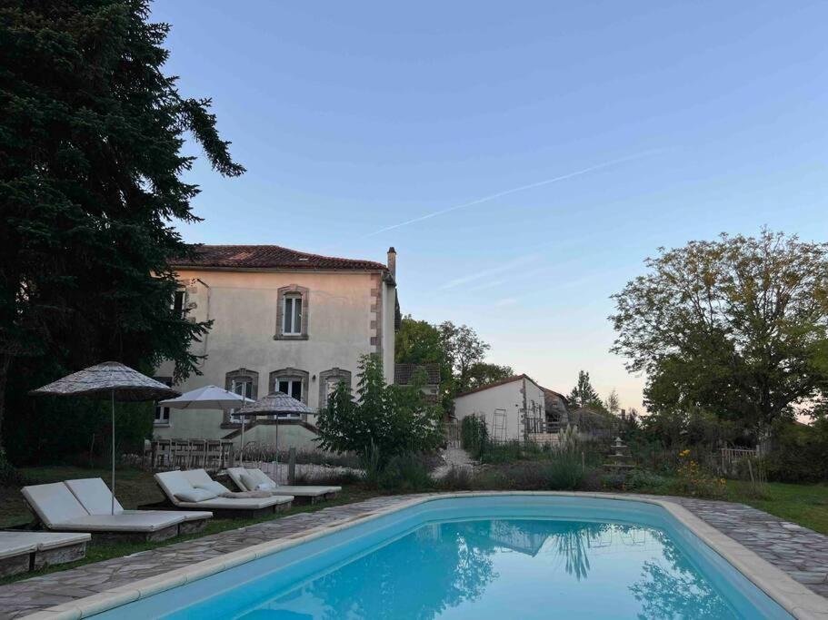 a swimming pool in front of a house at Maison Favori in Le Beugnon
