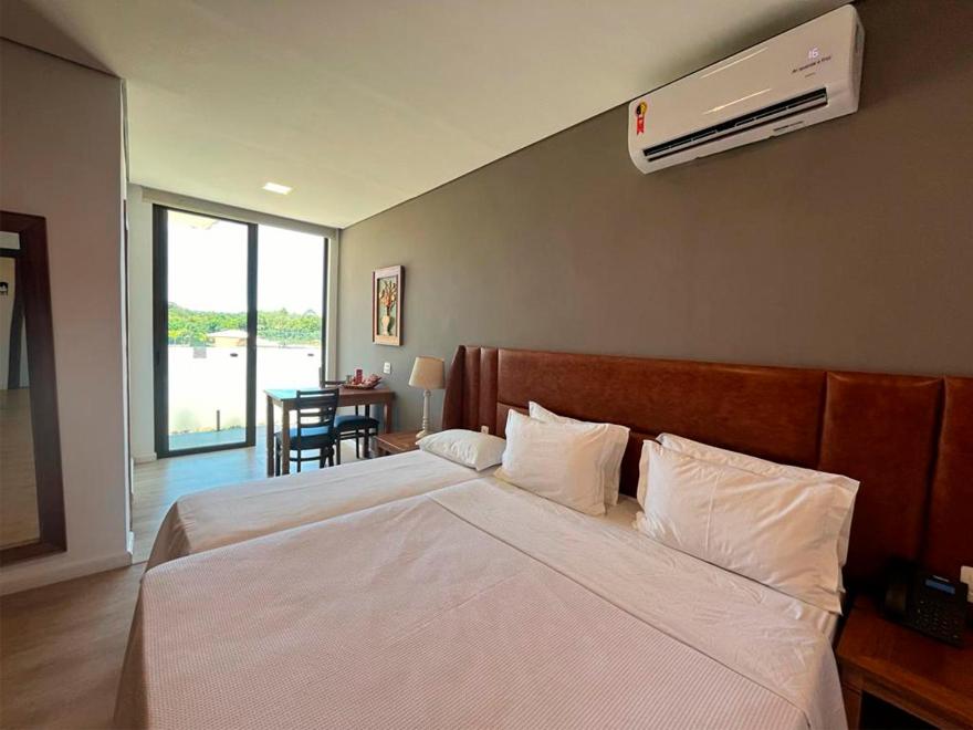 a bedroom with a large bed with a air conditioner at Santíssimo Resort in Tiradentes