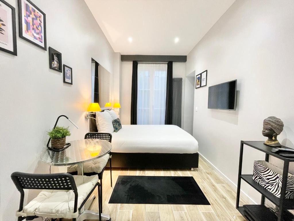 a bedroom with a bed and a table and chairs at Charming Studette Paris La Défense in Puteaux