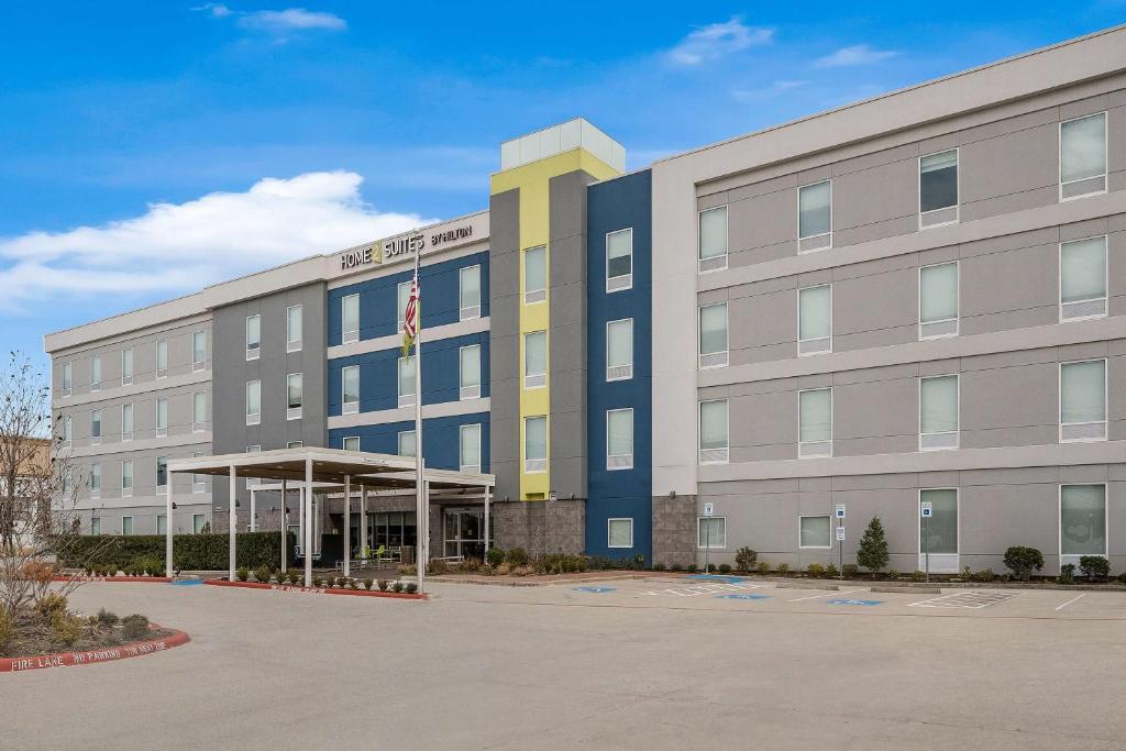 an office building with a parking lot in front of it at Home2 Suites By Hilton Baytown in Baytown