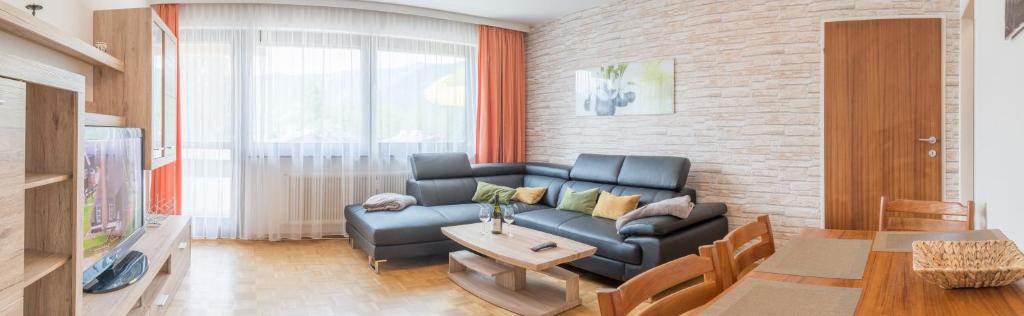 een woonkamer met een bank en een tafel bij Apartment Seeblick in Zell am See