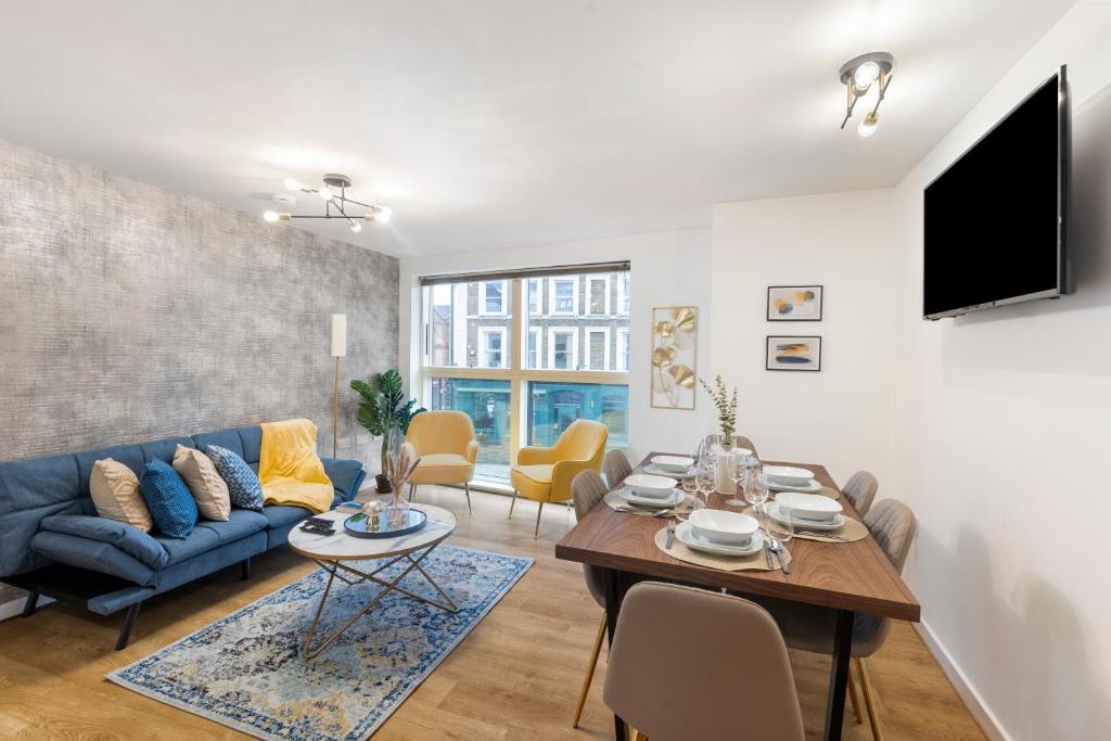 a living room with a blue couch and a table at Tranquil Urban Haven in London