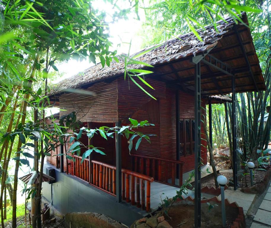 Ambalavayal的住宿－Misty Morning Resorts Wayanad，森林中带阳台的小型木屋