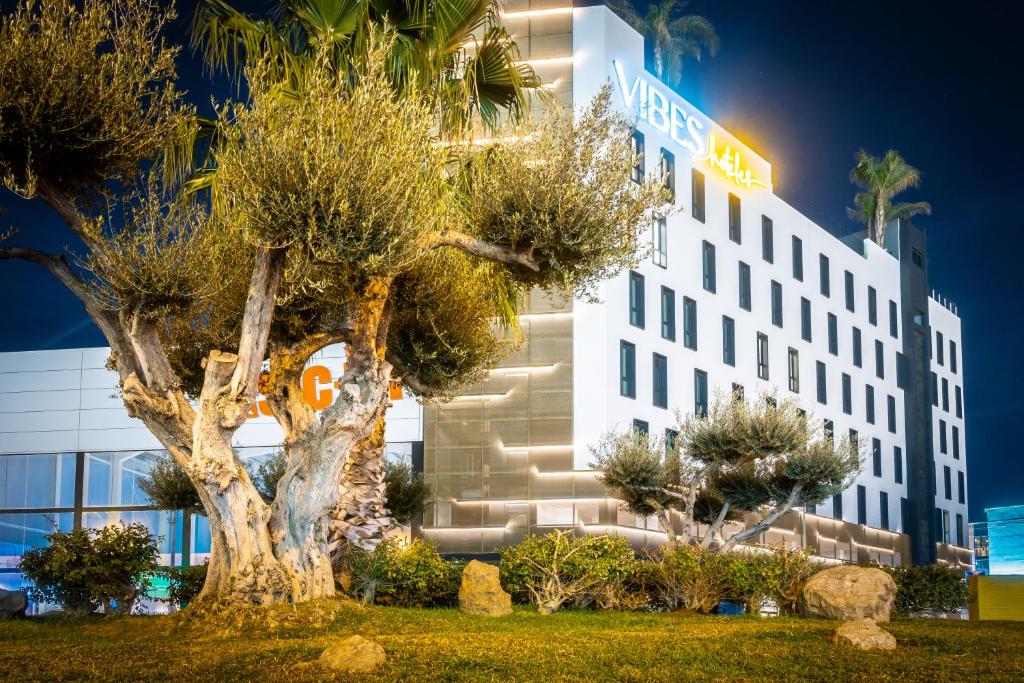 a hotel with a tree in front of a building at Hotel Málaga Vibes in Málaga