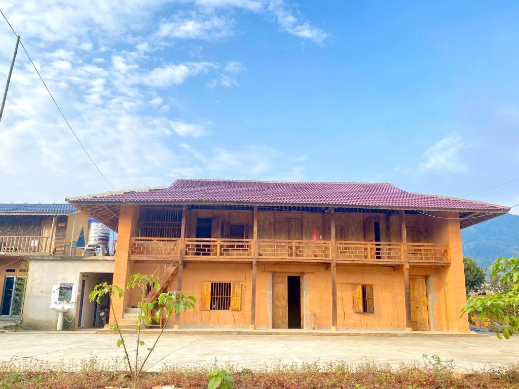 un ancien bâtiment avec un toit rouge dans l'établissement Tình Diễn homestay, à Quản Bạ