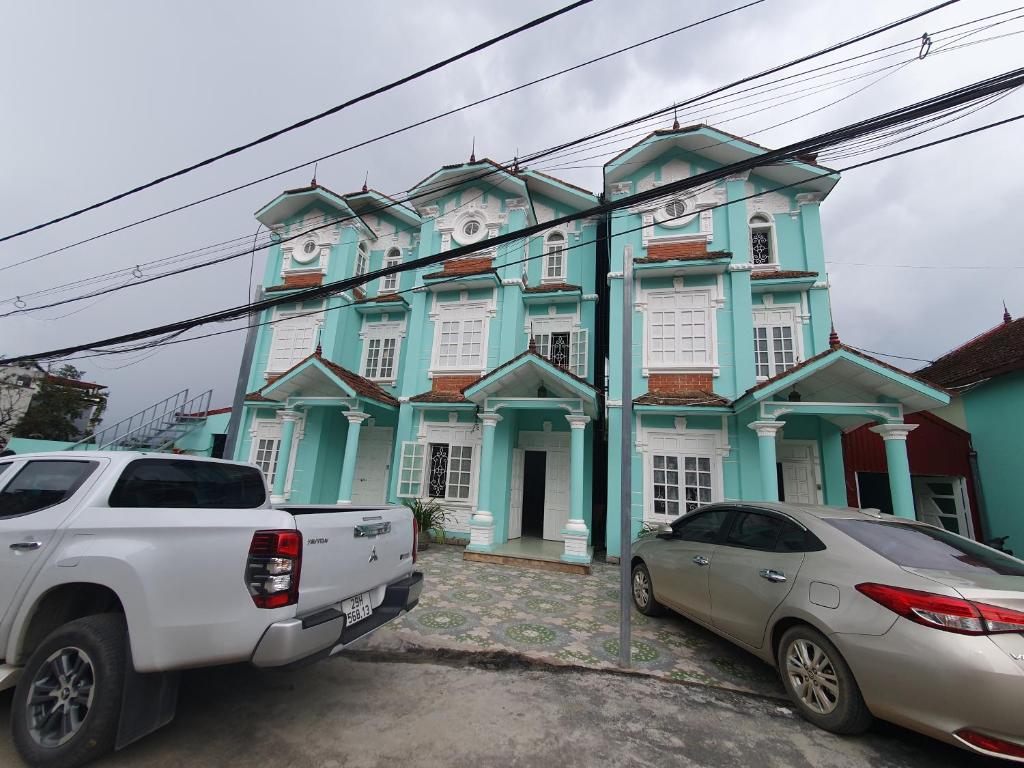 un bâtiment bleu avec des voitures garées devant lui dans l'établissement Cyan Sapa Homestay, à Sa Pa