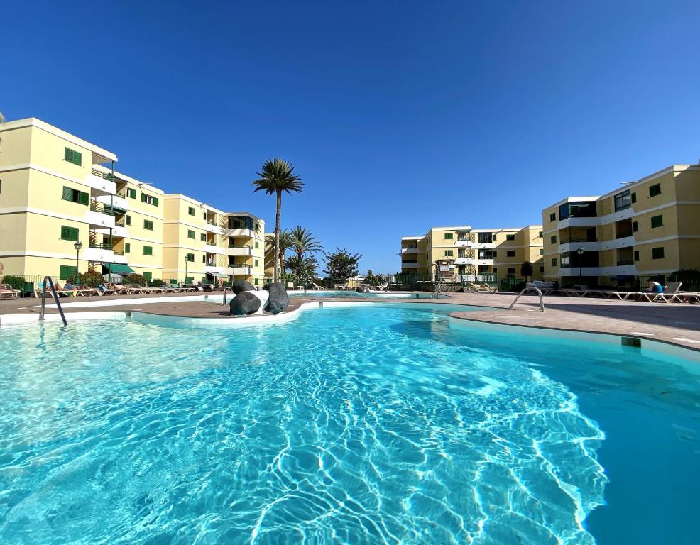 een groot zwembad voor sommige appartementsgebouwen bij P&L HOUSE Las Olas in Playa del Inglés