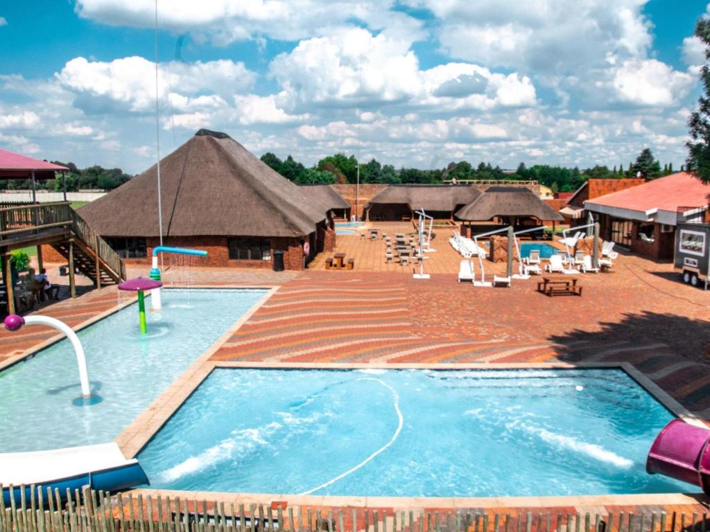 una piscina en un complejo con una hacienda en Bokamoso Lodge and Conference Centre, 