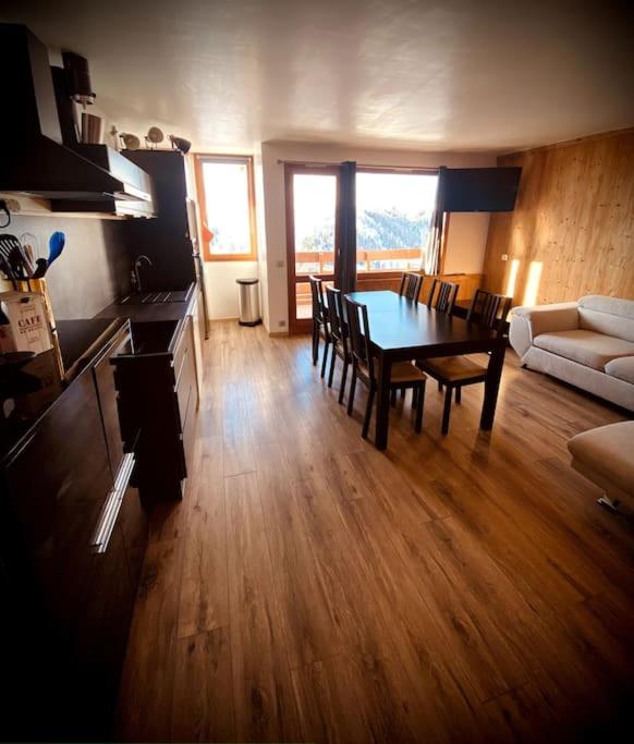 un salon avec une table et un canapé dans l'établissement Joli appt 6 pers 2ch Belle Plagne pied des pistes, à La Plagne Tarentaise