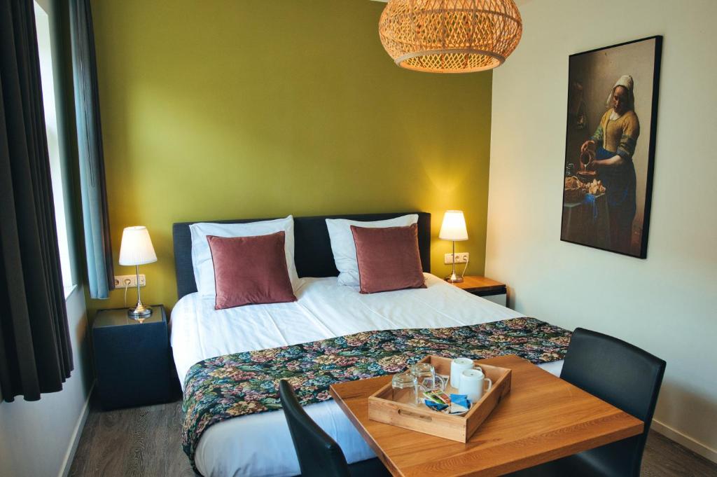 een hotelkamer met een bed en een houten tafel bij B&B De Hofnar Roermond in Roermond