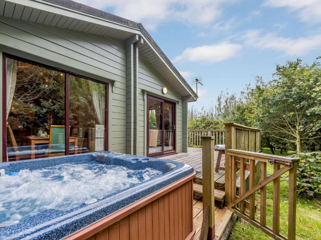 a hot tub on a deck next to a house at 3 Bed in Clovelly 85290 in Woolfardisworthy