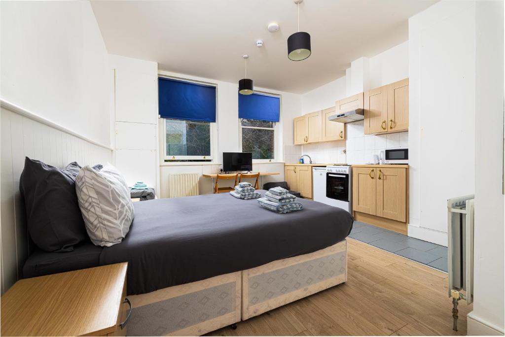 a bedroom with a large bed and a kitchen at Large Studio on Finchley Road 10 in London