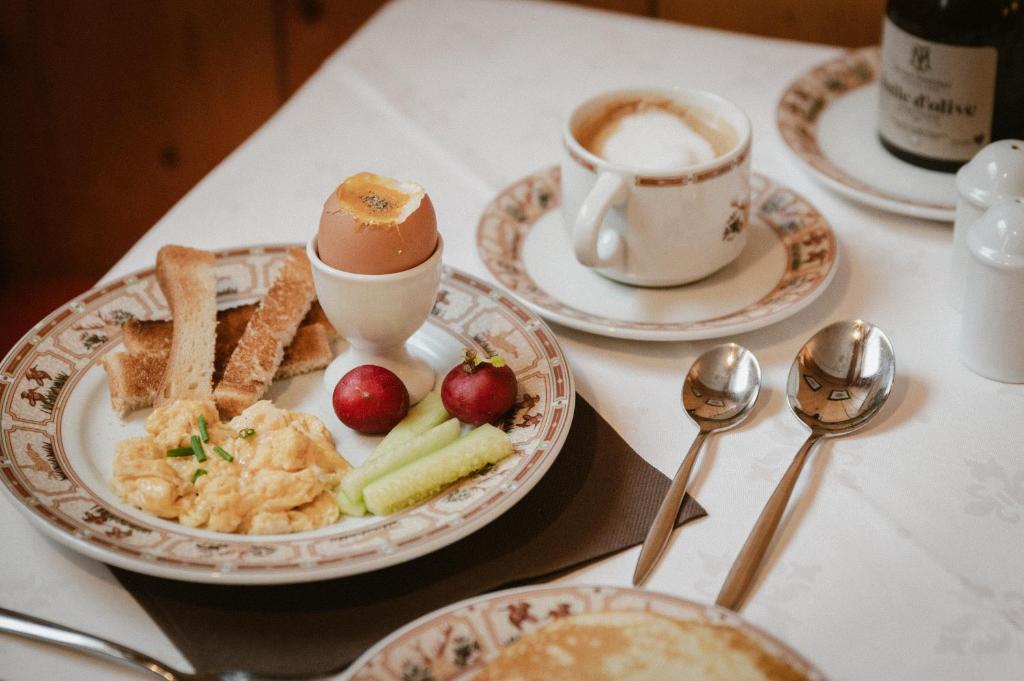 a table with a plate of food and a cup of coffee at Hôtel Alpen Ruitor in Méribel
