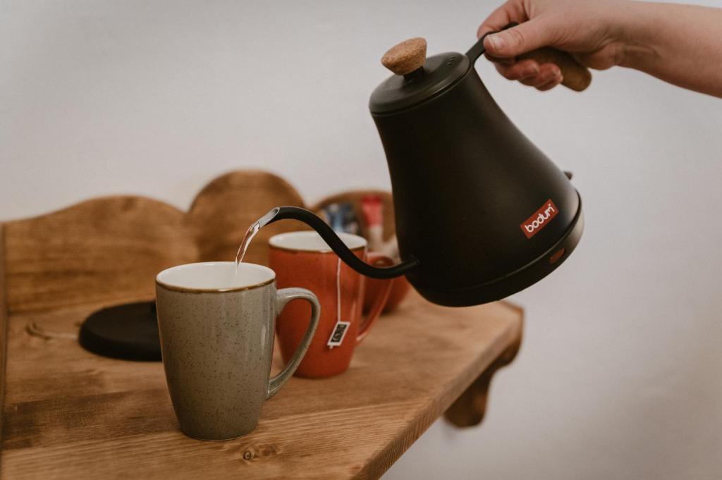 a person is pouring coffee into a cup at Hôtel Alpen Ruitor in Méribel