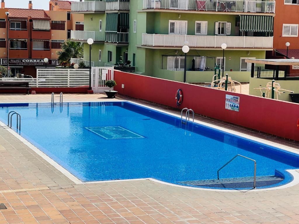 une grande piscine bleue à côté d'un bâtiment dans l'établissement Terraza del sol, à Candelaria