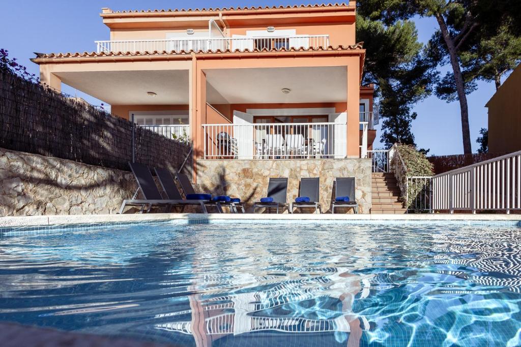 a villa with a swimming pool in front of a house at Chalet Mirador 3A in Alcanada