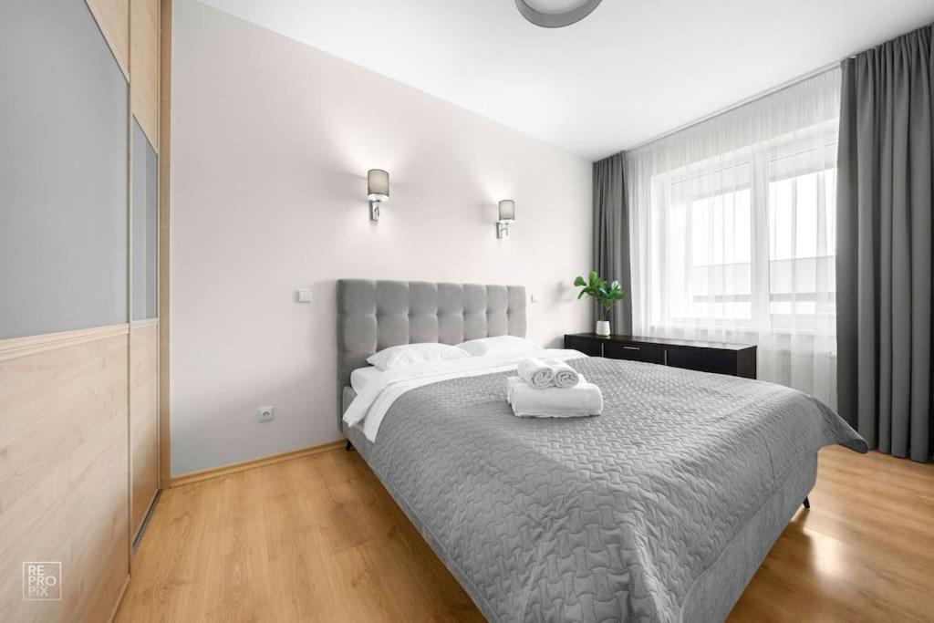 a bedroom with a large bed with two towels on it at Apartment with cozy balcony by URBAN RENT in Kaunas