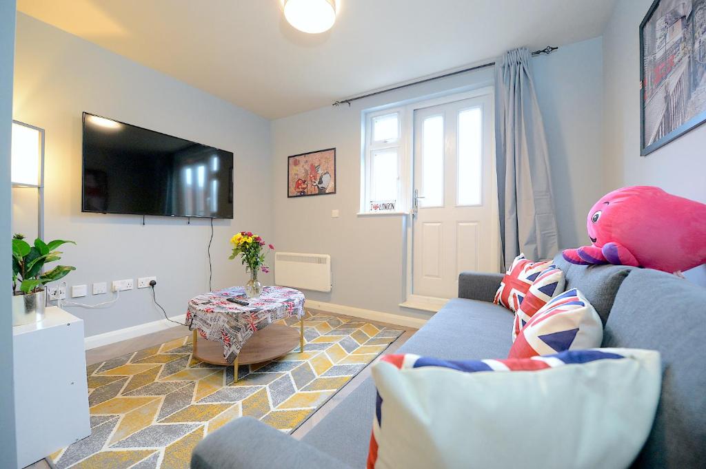 a living room with a blue couch with a teddy bear sitting on it at 2 BED TERRACED FLAT PICCADILLY LINE in London