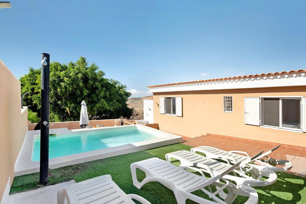 a yard with chairs and a swimming pool at Los Corcos Rural Farm With Private Pool in Playa de San Juan