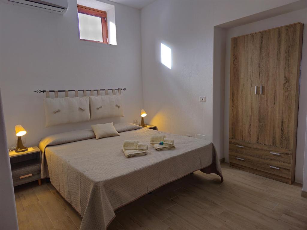 a bedroom with a bed with two towels on it at Case vacanza La Palmas nel centro di Malfa in Malfa