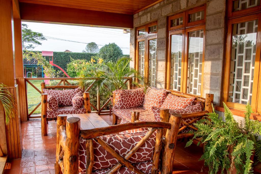 a screened in porch with two chairs and a table at United nations Bluezone stunning spacious cottage in Nairobi