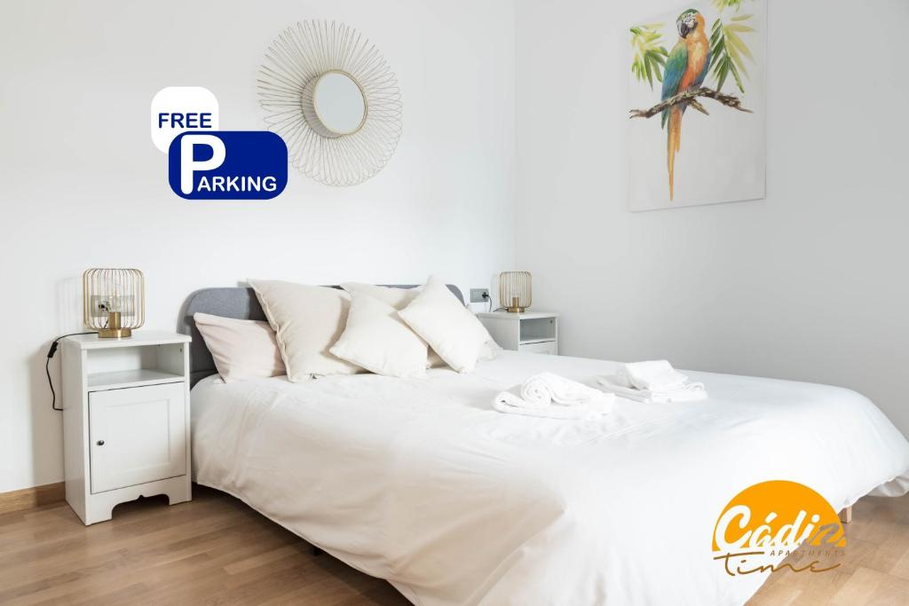 a bedroom with a white bed and a mirror at Corazon del Mar - FREE PARKING by Cadiz Time in Cádiz