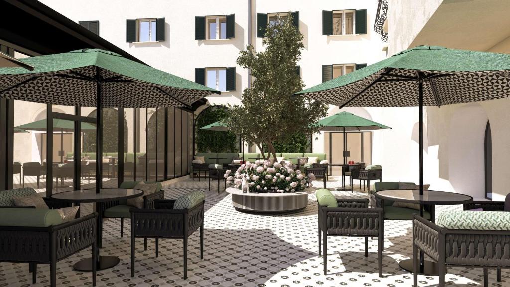 un patio con mesas y sillas en Anglo American Hotel Florence, Curio Collection By Hilton, en Florencia