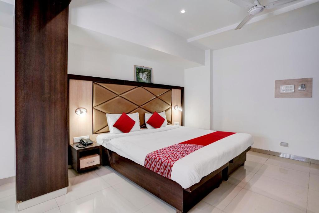 a bedroom with a large bed with red pillows at Super OYO Flagship Hotel Everest Lodging Vashi in Mumbai