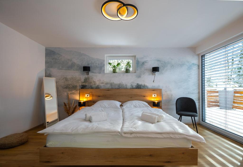 1 dormitorio con 1 cama blanca grande y ventana grande en Hiša Zima, en Gozd Martuljek