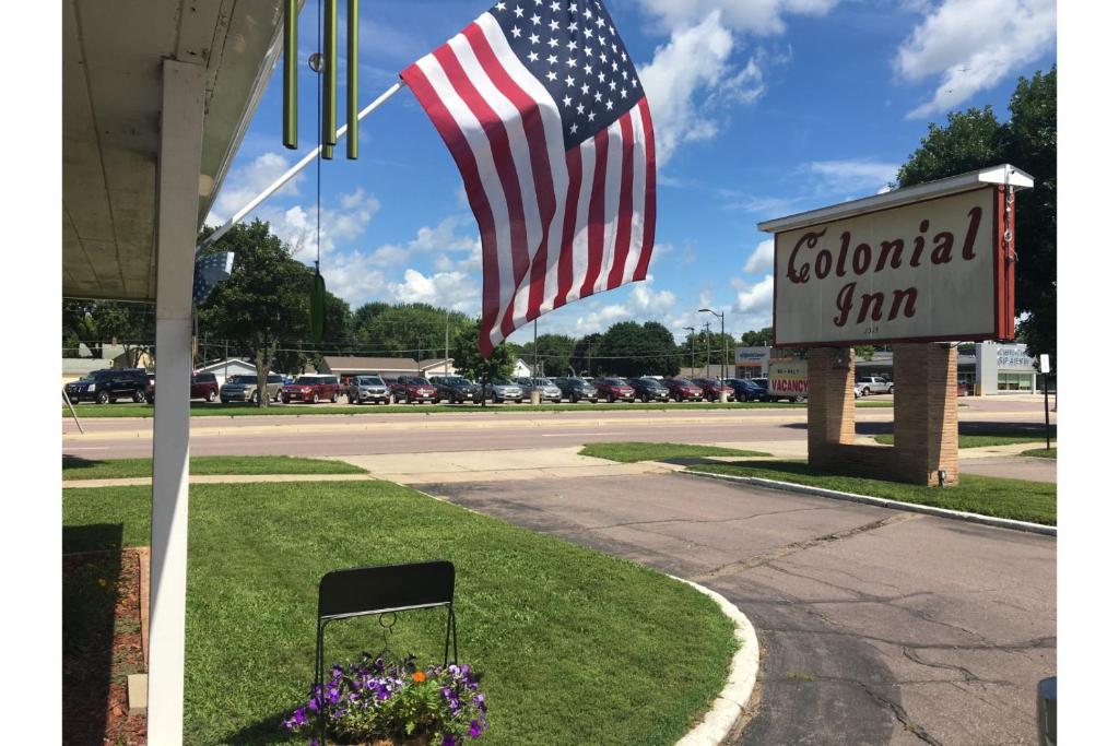 an american flag flying next to a gas station at Colonial Inn Extended Stay by OYO New Ulm in New Ulm