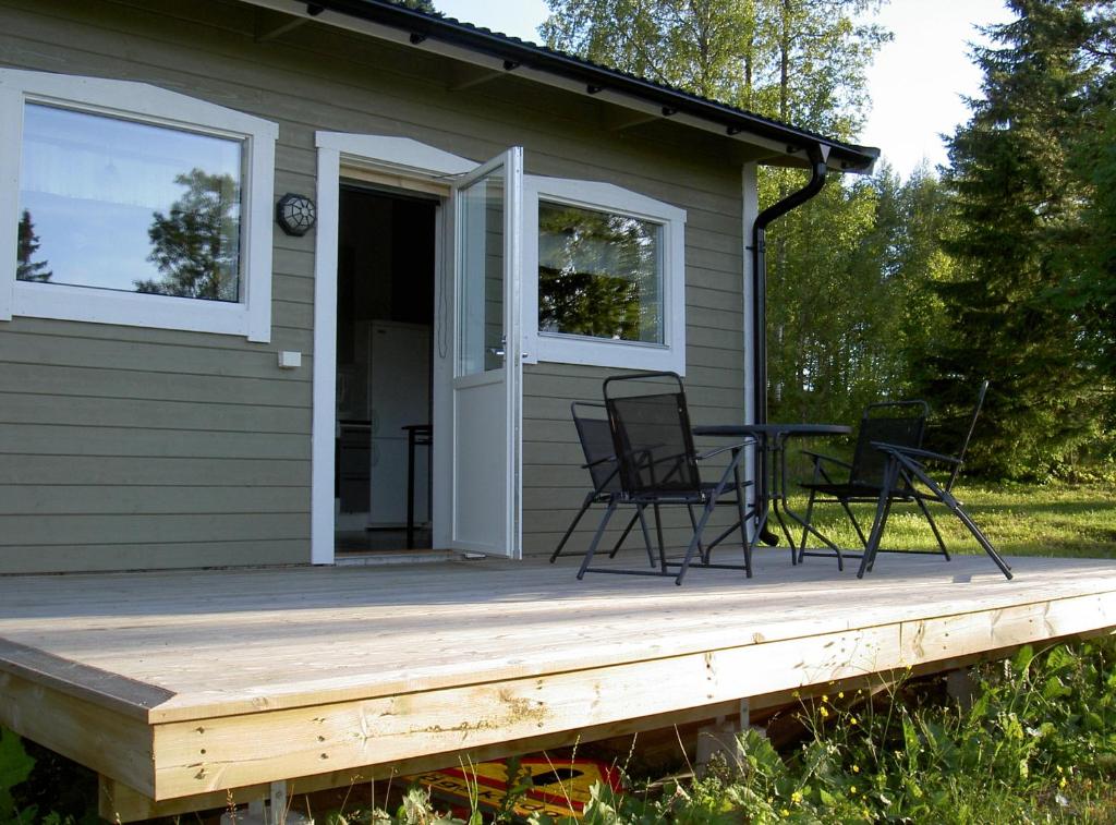 a porch with chairs and a table on a house at Elvis Stuga in Östersund