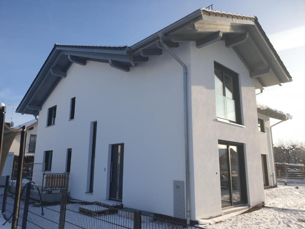 a white house with a black roof at Appartement an der alten Linde in Weil