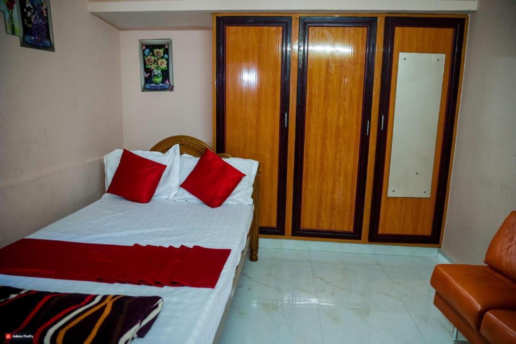 een slaapkamer met een bed met rode kussens bij Garuda Grand in Tirupati