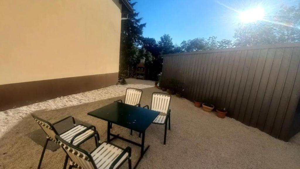 patio con 3 sedie, tavolo e recinzione di Ferienwohnungen Mach a Steinbach am Attersee