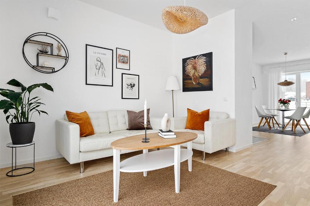 uma sala de estar com um sofá branco e uma mesa em Luxurious newly built villa with patio and private parking em Sigtuna