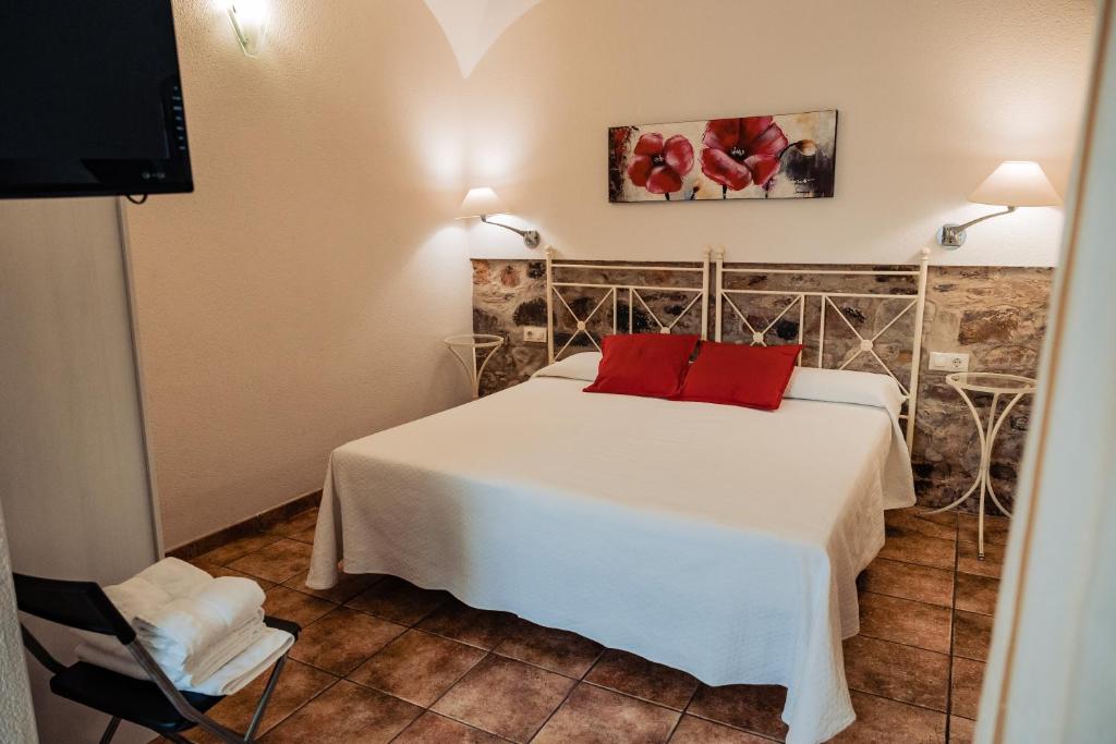 カセレスにあるApartamento Las Avutardas 1のベッドルーム(白いベッド、赤い枕付)
